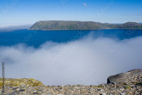 View from northern stony coast of Havoya towards Hjelmsoya island, Norway photo