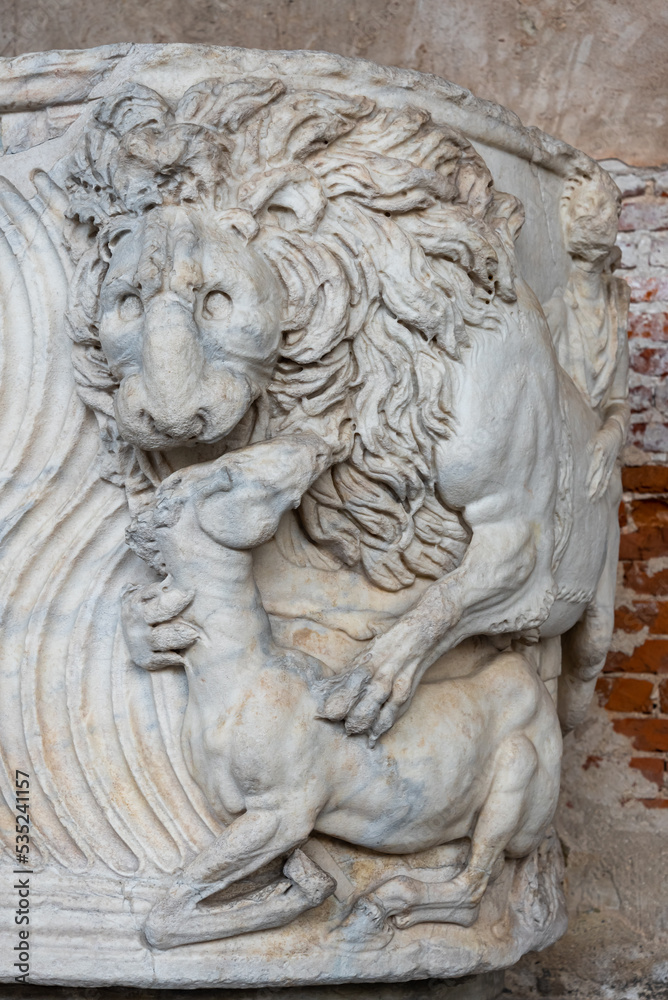 Sculptures of lion attacking a foal carved in marble wall