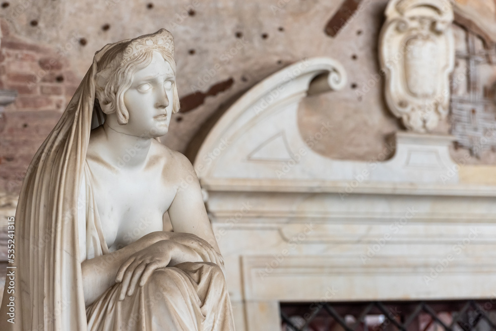Beautiful half naked woman wearing a veil sculpted in marble inside building in Pisa