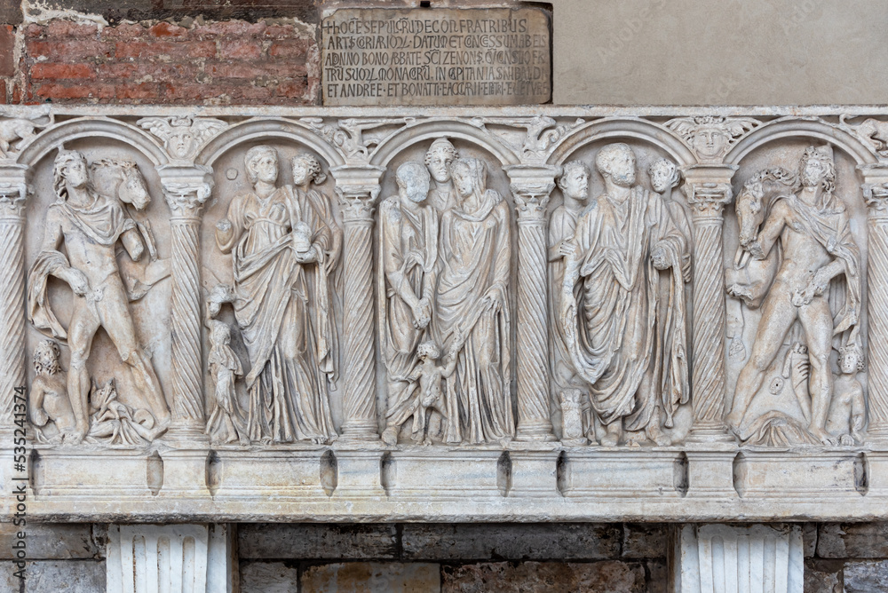 Roman characters carved in marble wall decorating monument in Pisa