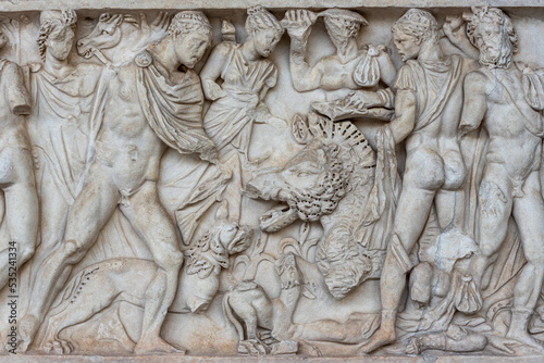 Sculptures carved in marble wall showing a group of naked men in a hunt in ancient Rome