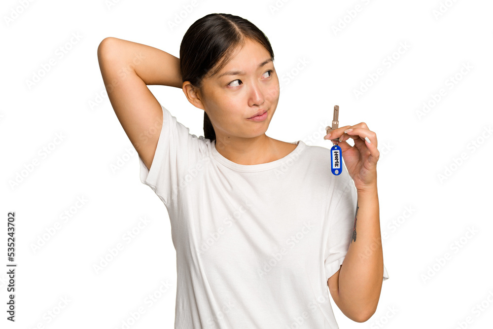 Young asian woman holding home keys isolated on green chroma background touching back of head, thinking and making a choice. Young asian woman holding home keys isolated on green chroma background touching back of head, thinking and making a choice.