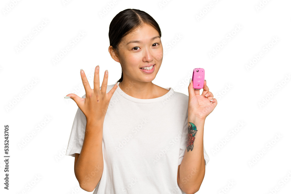 Young asian woman holding car keys isolated on green chroma background smiling cheerful showing number five with fingers. Young asian woman holding car keys isolated on green chroma background smiling cheerful showing number five with fingers.