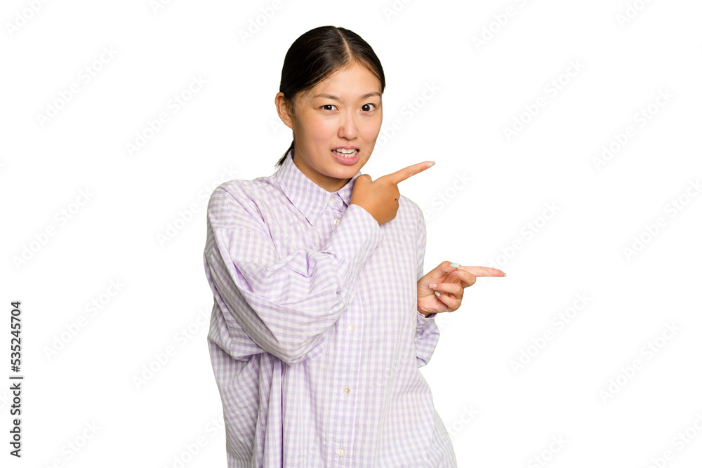 Young Asian woman isolated on green chroma background pointing with forefingers to a copy space, expressing excitement and desire. Young Asian woman isolated on green chroma background pointing with forefingers to a copy space, expressing excitement and desire.