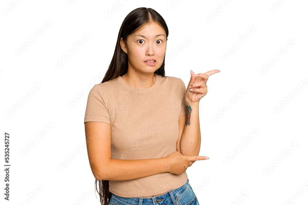 Young Asian woman isolated on green chroma background shocked pointing with index fingers to a copy space. Young Asian woman isolated on green chroma background shocked pointing with index fingers to a copy space.
