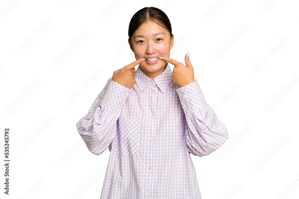 Young Asian woman isolated on green chroma background smiles, pointing fingers at mouth. Young Asian woman isolated on green chroma background smiles, pointing fingers at mouth.