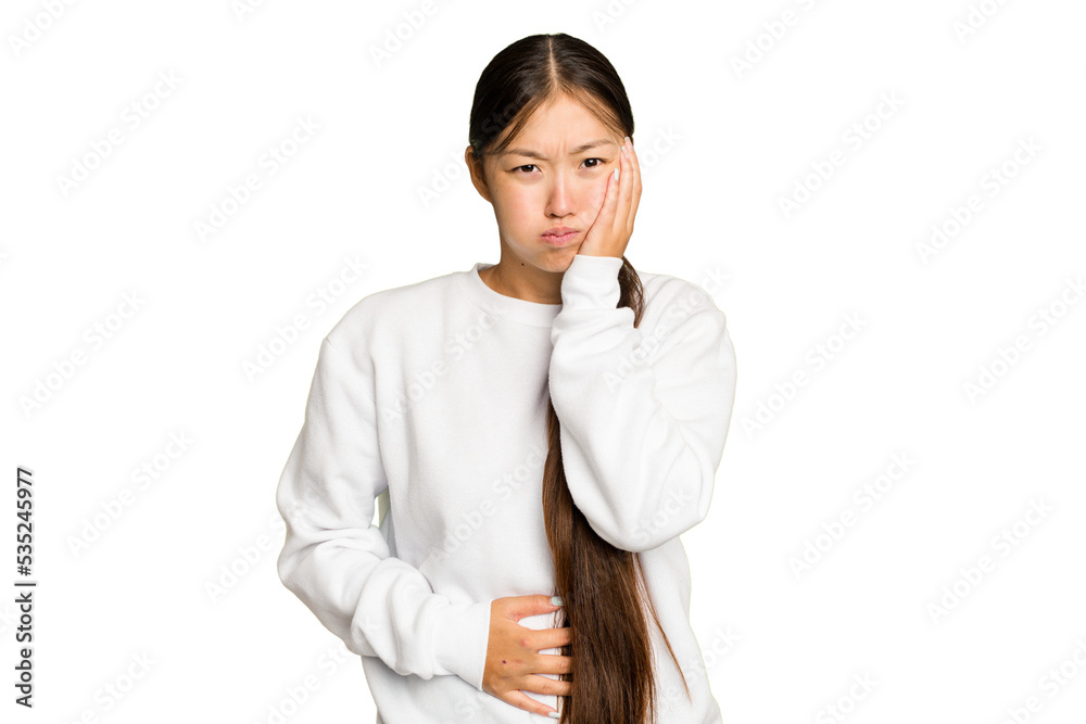 Young Asian woman isolated on green chroma background blows cheeks, has tired expression. Facial expression concept.