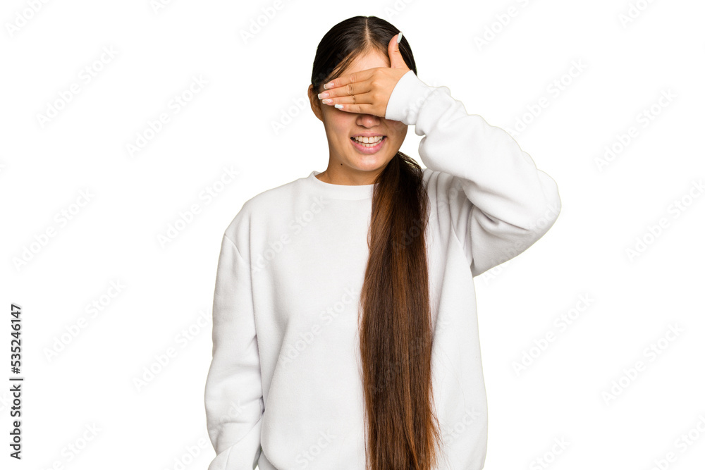 Young Asian woman isolated on green chroma background covers eyes with hands, smiles broadly waiting for a surprise. Young Asian woman isolated on green chroma background covers eyes with hands, smiles broadly waiting for a surprise.