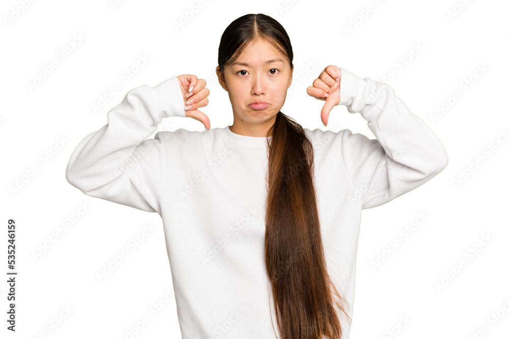 Young Asian woman isolated on green chroma background showing a dislike gesture, thumbs down. Disagreement concept. Young Asian woman isolated on green chroma background showing a dislike gesture, thumbs down. Disagreement concept.