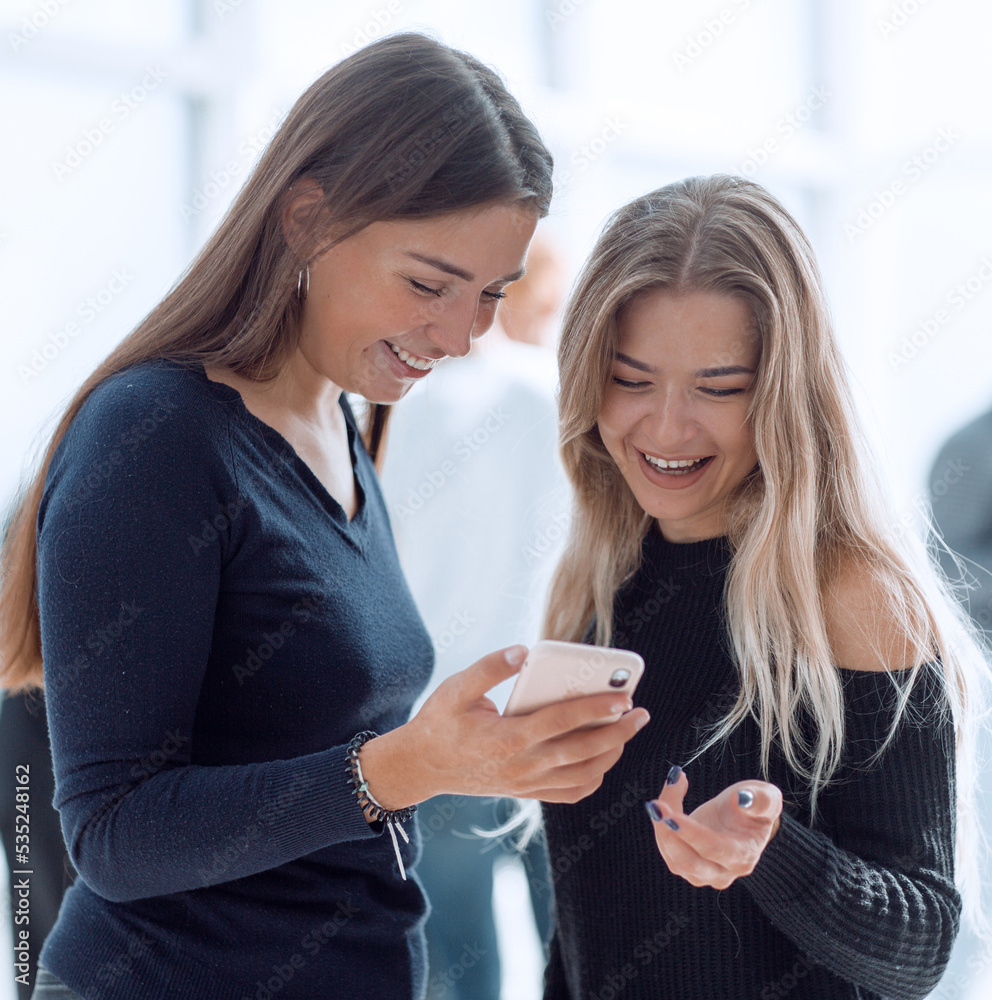 young colleagues reading a message on their smartphone young colleagues reading a message on their smartphone