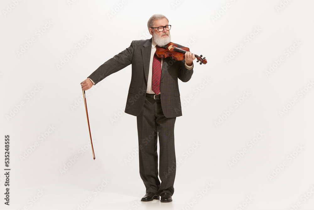 Obraz premium Senior man, musician playing violin isolated over white studio background. Concept of retro, vintage fashion style, art, music