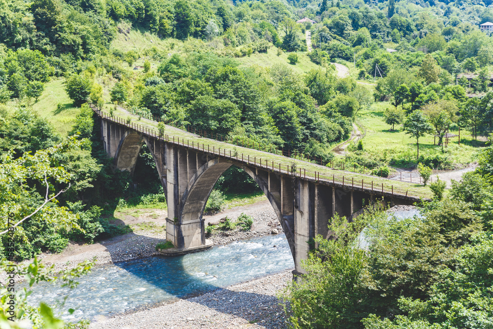 Abandoned railway bridge. Mountain landscape with a stone bridge over the river. Abkhazia. 