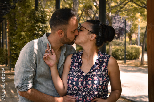 Pareja de enamorados chico y chica en un paseo rodeado de árboles en otoño