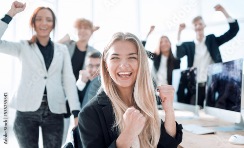 young woman on the background of a jubilant business team.