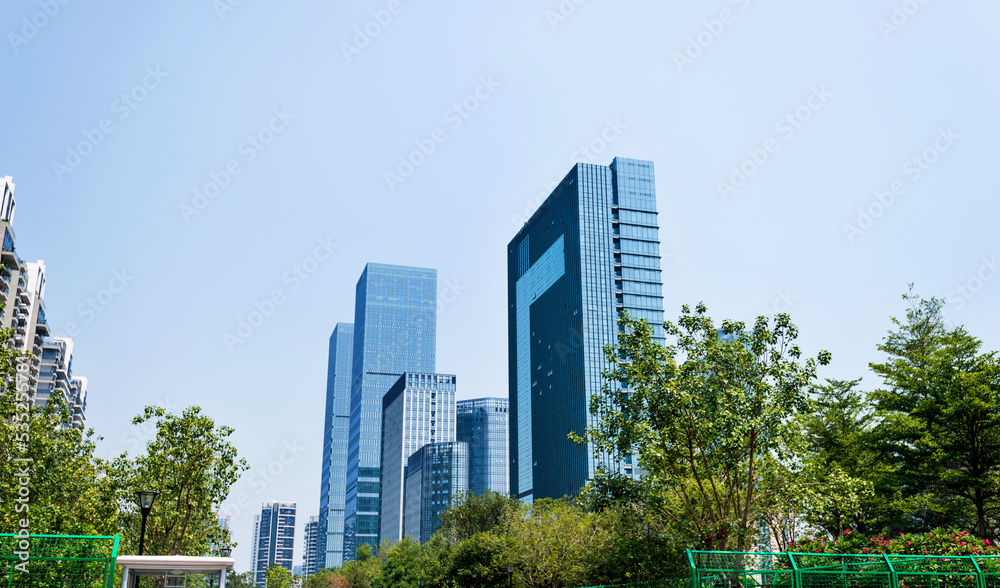 Modern glass buildings and green tree branches