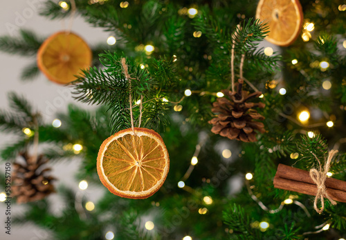 Decorated Christmas tree closeup. DIY dried oranges, cones and cinnamon sticks. eco friendly Christmas tree ornaments