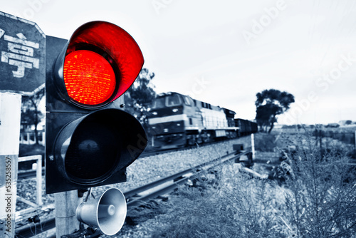 Chinese characters stop and traffic light shows red signal next to railway