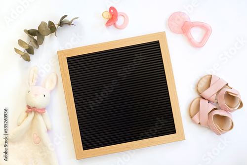 Blank pregnancy baby announcement mockup flat lay with blank letter board pacifier, toy and shoes