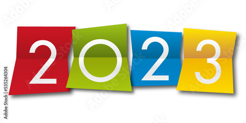 Carte de vœux 2023 avec l’année inscrite sur quatre papiers de couleurs différentes, pour présenter la nouvelle année.