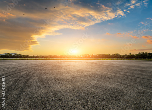 Empty asphalt race track road and green forest with sky clouds at sunset © ABCDstock