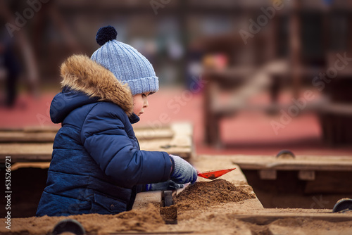 little boy playing in the sandbox