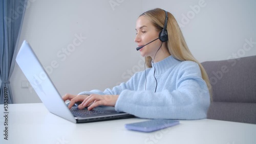 Woman in headset working online. IT support speacialist speaking with customer on video call photo