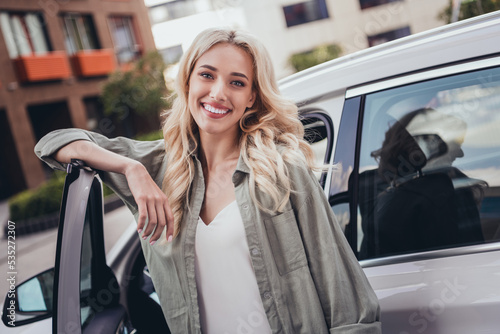 Portrait of pretty positive lady toothy smile good mood standing near car open door outside