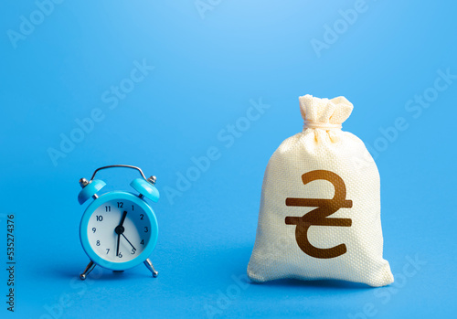 Time and ukrainian hryvnia money bag. Loans, mortgages. Retirement funds. ROI. Bonds, dividends. Deposits, savings. Bank. Investments. Hourly pay. Time of payment in the contract. Taxation