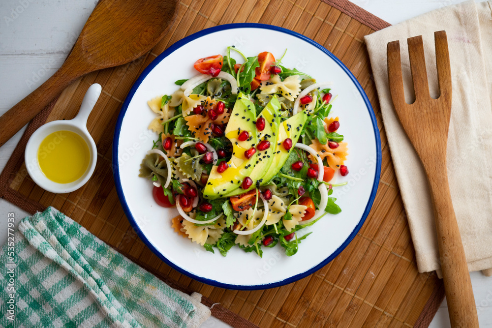 Argula salad with pasta bows, avocado, cherry tomatoes, pomegranate and sesame. Argula salad with pasta bows, avocado, cherry tomatoes, pomegranate and sesame.