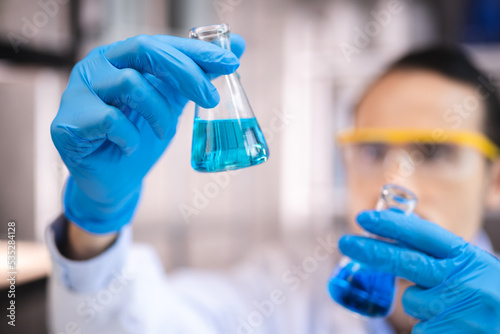 blue chemical liquid experiment in scientific glassware equipment in science medicine laboratory, chemistry or biology research discovery by using glass of test tube or beaker and flask