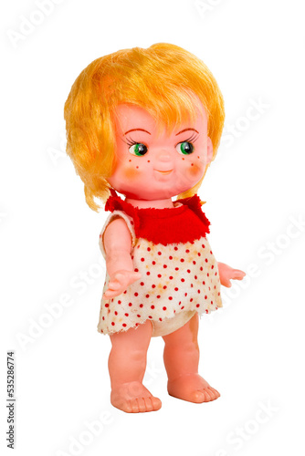 Plastic and rubber isolated vintage doll in a red and white polka dot dress and orange red hair with freckles