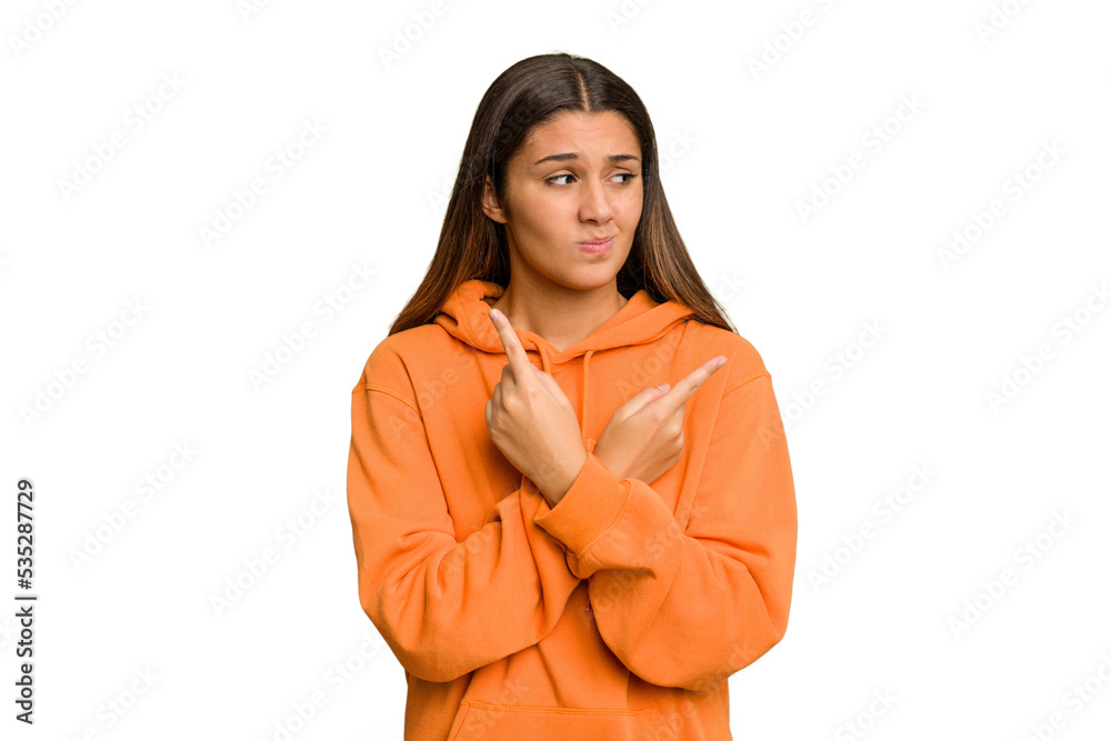 Young Indian woman isolated cutout removal background points sideways, is trying to choose between two options. Young Indian woman isolated cutout removal background points sideways, is trying to choose between two options.