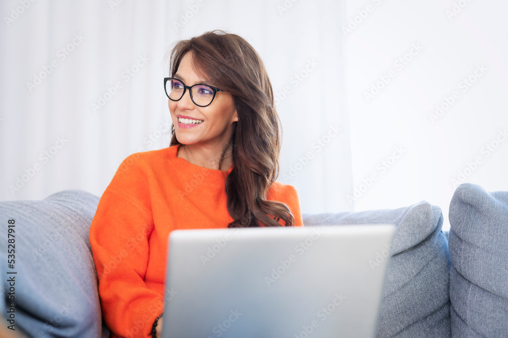 Smiling woman using her laptop and working at home Smiling woman using her laptop and working at home