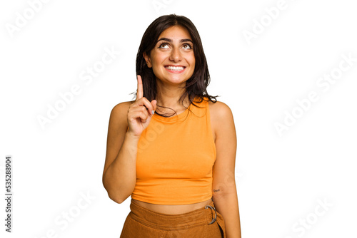 Фотография Young Indian woman isolated on green chroma background indicates with both fore fingers up showing a blank space