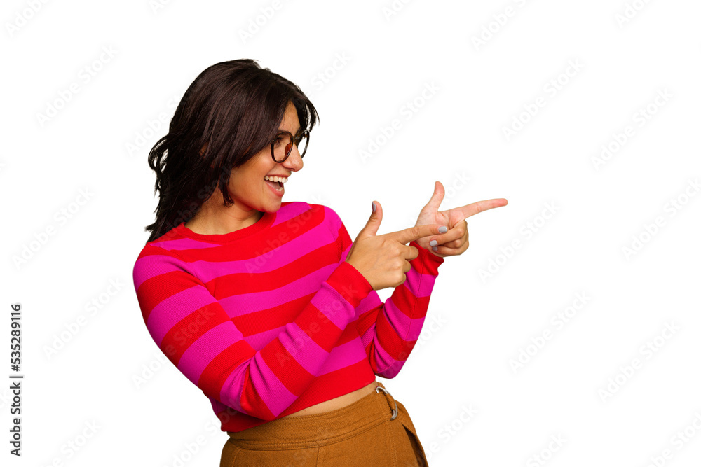 Young Indian woman isolated on green chroma background points with thumb finger away, laughing and carefree. Young Indian woman isolated on green chroma background points with thumb finger away, laughing and carefree.