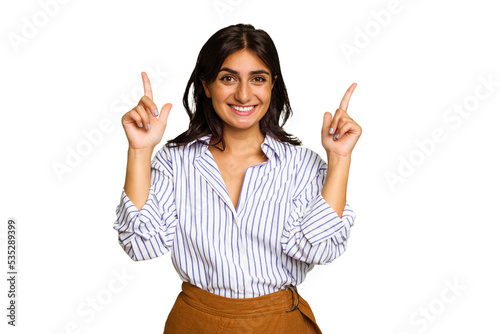 Картината върху платно Young Indian woman isolated on green chroma background indicates with both fore fingers up showing a blank space