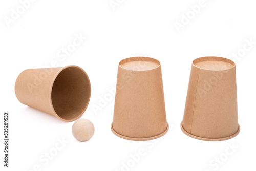 Three paper cups and wood ball, guessing shell game equipments, isolated on white background