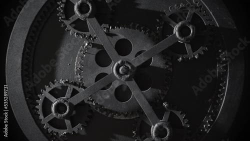 Retro mechanism with five rotating gears. Vintage cogwheels of machine in ancient old factory. Moving engine parts and internal details, steampunk concept. Isolated on black, zoom in