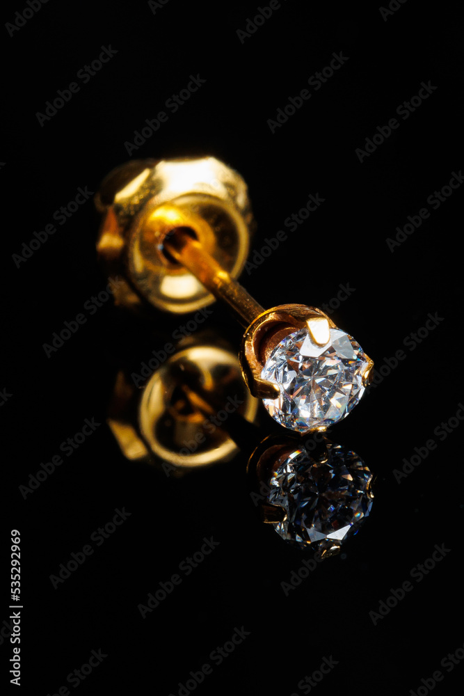 Jewelry with stones earrings, luxury golden earrings with diamonds, jewels on a black background. Jewelry with stones earrings, luxury golden earrings with diamonds, jewels on a black background.