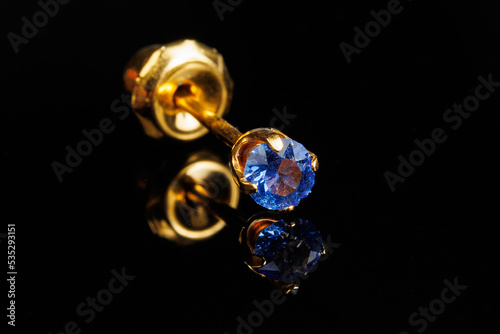 Jewelry with stones earrings, luxury golden earrings with diamonds, jewels on a black background.