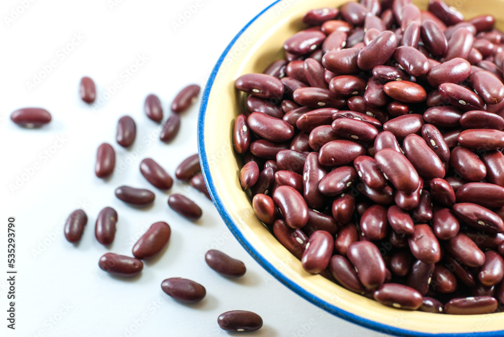 Red beans in enameled metal bowl placed on a white floor, closeup, flat lay. Red beans in enameled metal bowl placed on a white floor, closeup, flat lay.