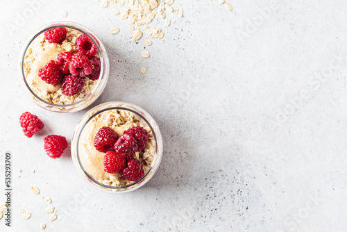 Overnight oatmeal with raspberries, currants and tahini in jars. Breakfast concept.