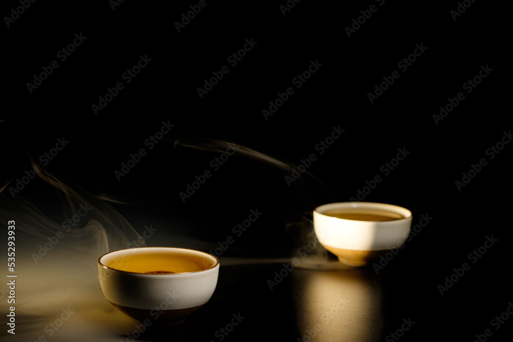 Two cups of chinese tea with steam isolated on black background. Top view Two cups of chinese tea with steam isolated on black background. Top view