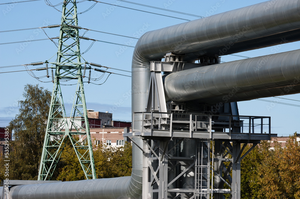 pipeline and power lines, in the photo pipelines and power line support on the background of the blue sky of the buildings of the city pipeline and power lines, in the photo pipelines and power line support on the background of the blue sky of the buildings of the city