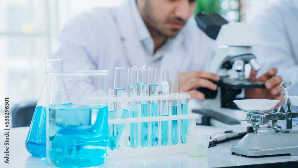 A microscope is being used for research in the lab by the group of young scientists. A microscope is being used for research in the lab by the group of young scientists.