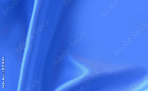 Blue silk with beautiful vertical folds. Solid blue background. Satin, silk, organza.