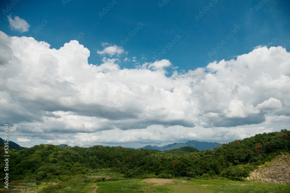 Green mountain landscape with white clouds