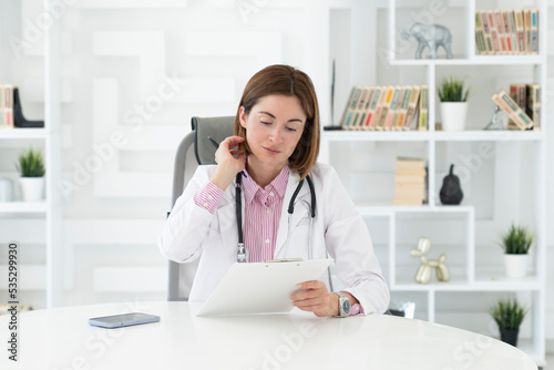 Portrait of attractive female doctor thinking and working in her modern office  © Vitaliy