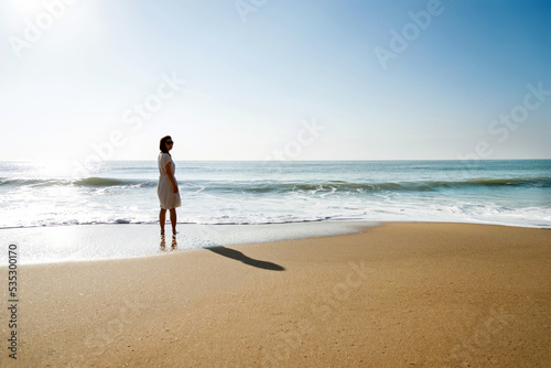 Young asian woman relaxing on the beach at sunrise.