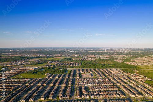 Panoramic view at established neighbourhood with town home cottage style houses in Canada. Top aerial view at middle class family homes with large backyard and green front yards. Very clean area.